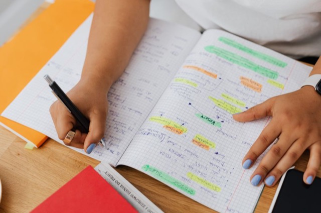 Aantekeningen in een schrift, gemarkeerd met gekleurde markeerstiften