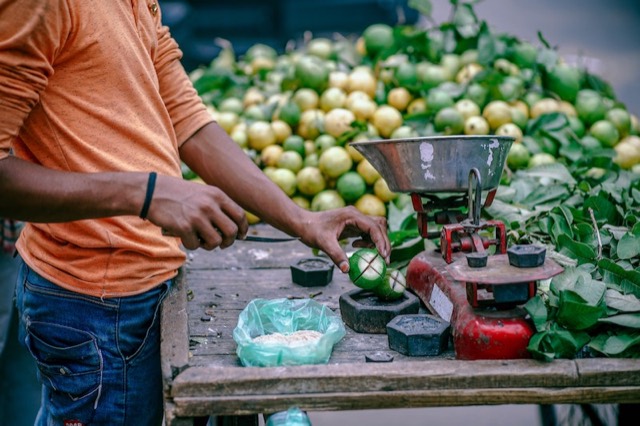 Handelaar weegt fruit af op een markt